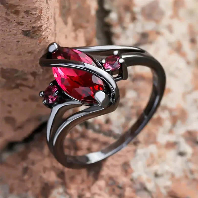 Elegant black ring with marquise red gemstone and side accents, stylish women&