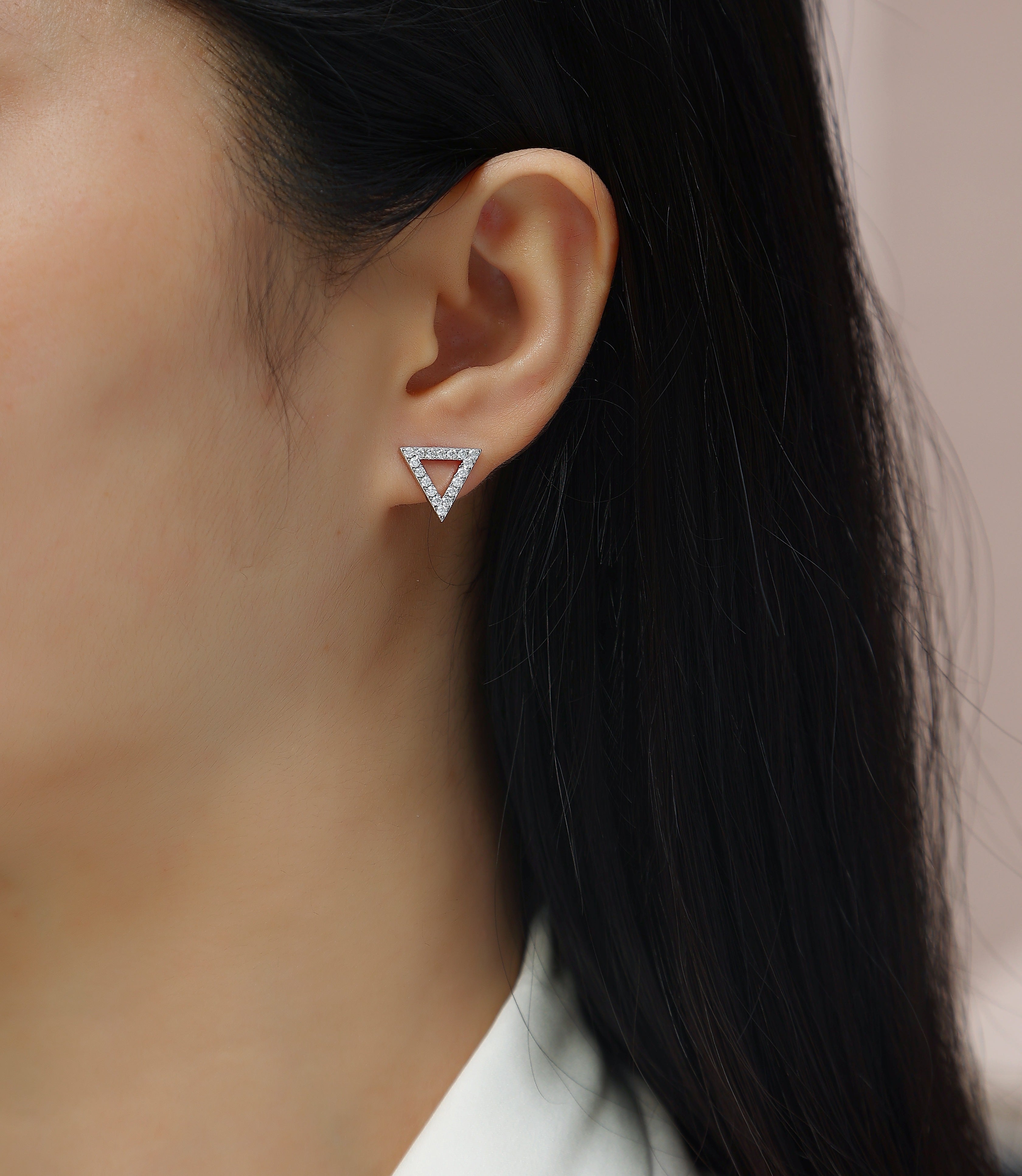 Moissanite stud earrings in triangle design, set with sparkling stones, worn by a model for a fashionable look.