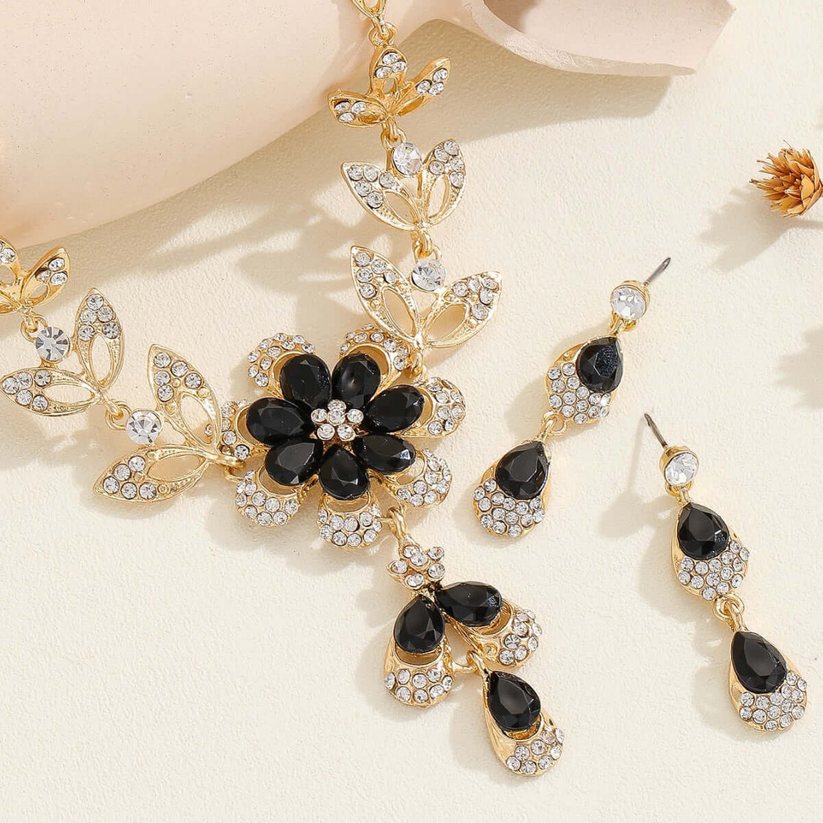Vintage jewelry set featuring a black alloy pendant necklace with matching earrings and intricate floral designs.