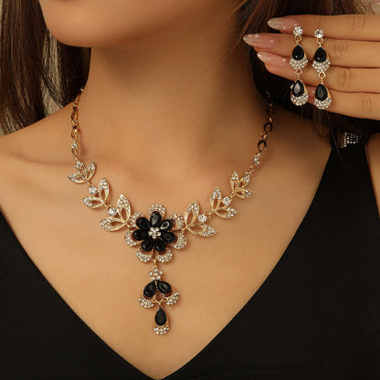 Vintage jewelry set featuring a black alloy necklace and matching earrings with floral design.