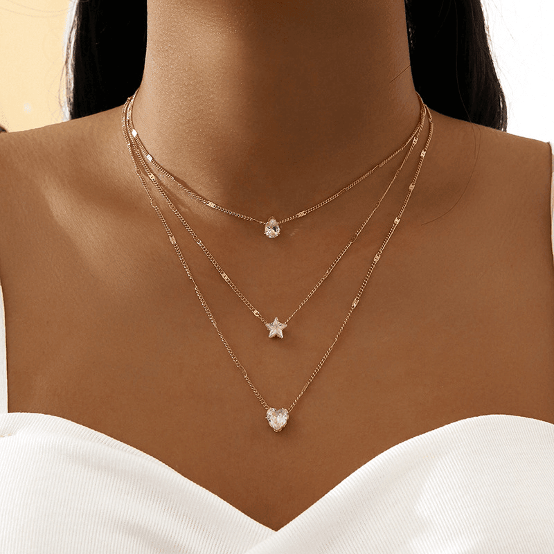 Layered gold necklaces with heart and star pendants