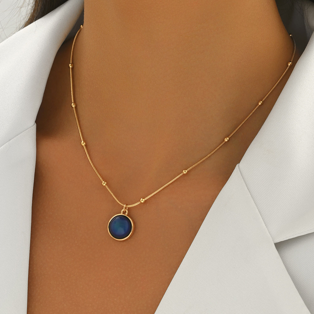 Gold necklace with a blue pendant 