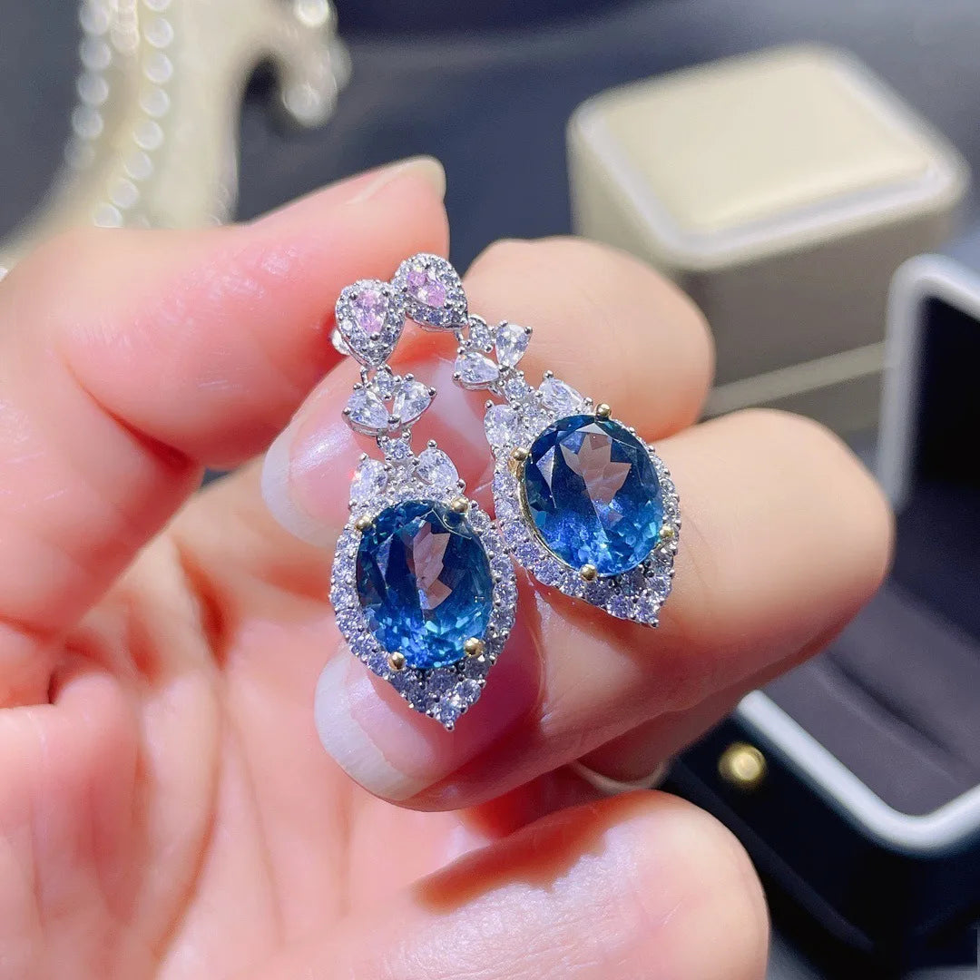 Sapphire Earrings Genuine 925 Sterling Silver Earring displayed in hand, featuring blue gemstones and intricate silver design.